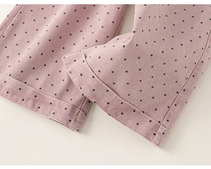 Detail view of pink polka dot children's trousers featuring wide folded hem and fine stitching