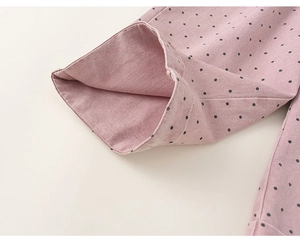 Close-up of pink polka dot fabric detail showing stitching and soft cotton texture
