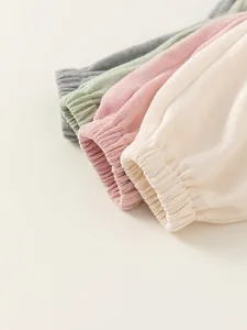 Close-up of children's ribbed hoodie cuffs in grey, mint, pink, and beige cotton fabric