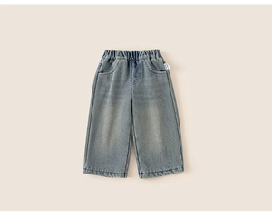 Détail d'un jean en denim délavé pour enfants avec taille élastique et texture douce