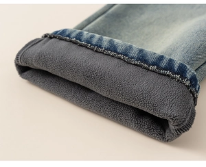 Détail d'un jean bleu pour fille montrant la doublure polaire grise épaisse