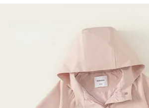 Close-up of pink hooded kids windbreaker with zipper and metal snap button closure