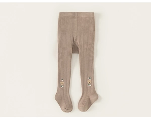 Detail of baby knitted leggings featuring cute bear embroidery and ribbed texture fabric