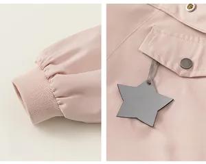 Detail view of pink jacket showing ribbed cuffs and star-shaped decorative tag
