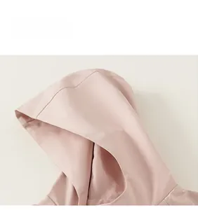 Close-up of hood stitching and smooth light pink fabric on children windbreaker jacket