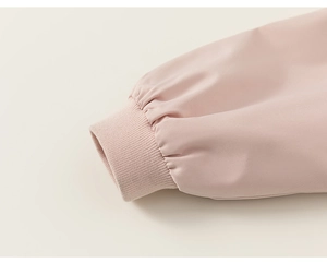 Detail of pink children's jacket showing the high-density ribbed knit cuffs and smooth fabric