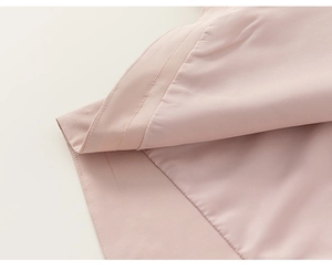 Detail of light pink chiffon fabric with precision double-stitch sewing on the garment hem
