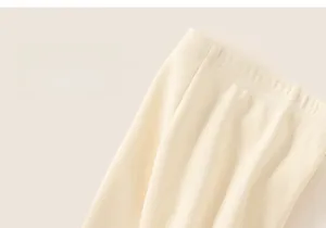 Detailed close-up of thick ribbed knit waistband on warm cream-colored winter pants