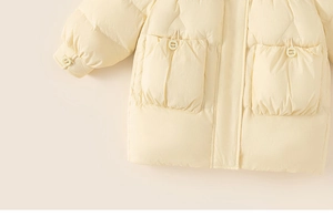 Detail view of cream yellow down jacket featuring large pockets and quilted texture