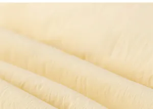 Macro view of light yellow down jacket fabric with natural wrinkle texture and high density