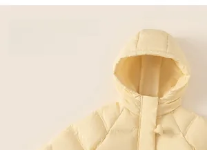 Detail of light yellow girls down coat with heart shaped button and windproof quilted fabric
