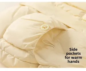 Detail view of cream-colored down jacket featuring side pockets and round buttons