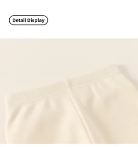 Close-up of the elastic waistband and ribbed knit texture on cream thermal pants