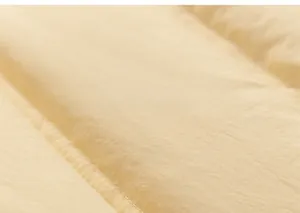 Macro shot of warm yellow quilted fabric showing detail of puffer jacket stitching and padding