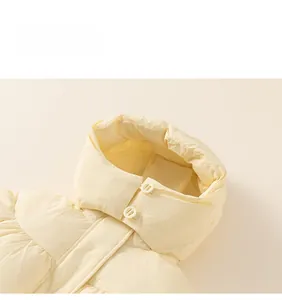 Detail view of the yellow hooded puffer jacket collar with two matching buttons