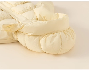 Detail shot of puffy cream down jacket with buttons and horizontal windproof fabric texture