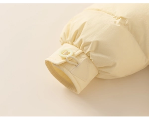 Close-up of elastic cuffs and decorative buttons on cream hooded down jacket