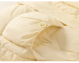 Detailed close-up of a cream yellow down jacket showing the pocket and ring fastener
