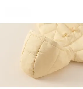 Detailed close-up of quilted winter jacket with hooded design and decorative buttons