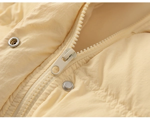Detail view of cream winter down jacket featuring premium resin zipper and silver metal snaps