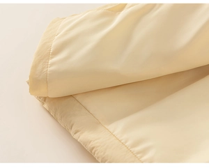 Detailed macro view of the light beige fabric texture and quilting on kids down jacket