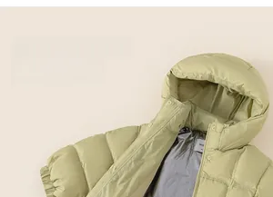 Detail of light green puffer coat showing black gold thermal lining and windproof fabric