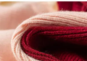 Close-up of pink and burgundy ribbed knit fabric showing soft wool texture and detail