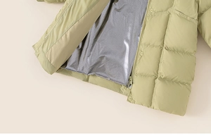 Detailed close-up of heat-reflective silver lining in a long down puffer coat