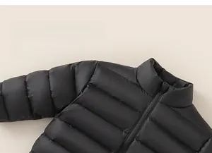 Détail de la doudoune matelassée noire pour enfant avec col montant et fermeture éclair