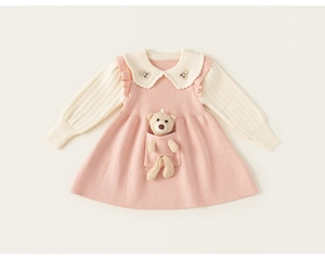 Detail of knit girls' dress with 3D teddy bear in pocket and ruffle collar accents