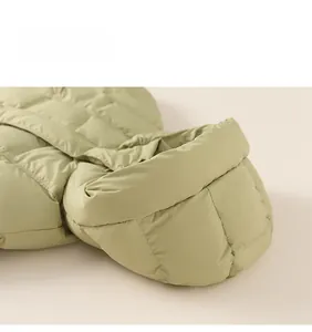 Detail view of grass green quilted down jacket showing puffy texture and high-quality seams