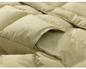 Close-up of quilted square pattern and pocket detail on olive green warm down jacket