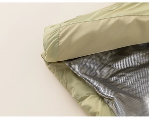 Detail of light sage green down jacket featuring silver thermal reflective lining technology
