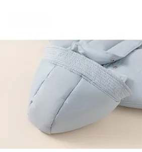 Detail of light blue hooded puffer jacket featuring quilting and metal snap buttons
