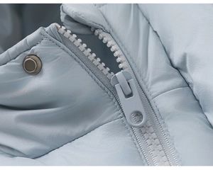 Detailed close-up of light blue down jacket with metal snap button and resin zipper