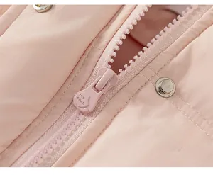 Detailed close-up of smooth metal zipper and snap button on pink puffer jacket