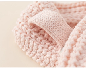 Vista macro dettagliata della trama in maglia rosa e dell'asola intrecciata sulla sciarpa