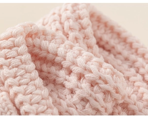 Dettaglio della trama in maglia grossa rosa chiaro per sciarpa invernale calda da bimbi