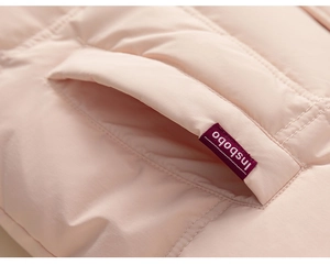 Detail shot of a pink quilted down jacket pocket with brand tag and premium stitching