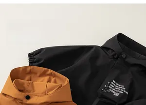 Detail of hooded kids outdoor jacket featuring windproof fabric and snap button neckline