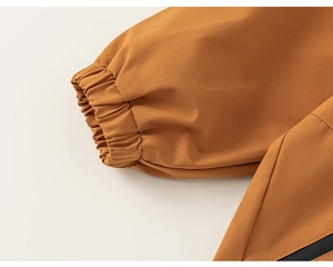 Detail of elastic cuffs and fine stitching on caramel windproof outdoor jacket