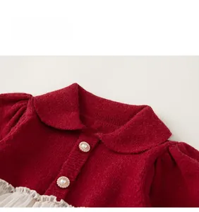 Detailaufnahme des roten Strickkleids mit Perlenknöpfen und weißem Netz-Rüschendetail