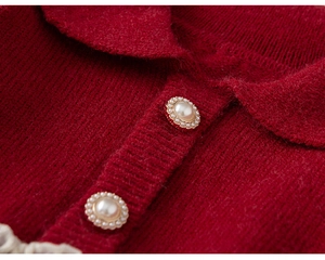 Detailaufnahme von rotem Strickstoff mit Vintage-Perlenknöpfen und Spitzenbesatz