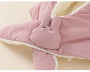 Detail van roze baby winterjas met pluche fleece voering en schattig konijnenborduurwerk