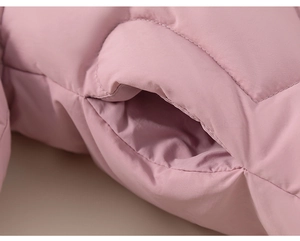 Detailweergave van gewatteerde zijzak en fijne stiksels op winterjas voor kinderen