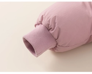 Detailopname van roze donsjack met geribbelde manchetten voor winddichte isolatie