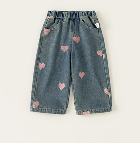 Detailed view of pink heart embroidery and elastic waistband on blue denim jeans