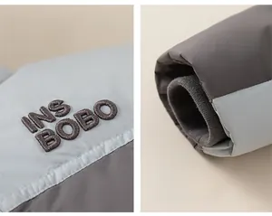 Detailed macro view of embroidered INS BOBO chest logo and windproof ribbed cuffs on jacket