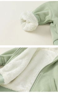 Détail de la veste enfant vert clair montrant la doublure polaire blanche et le poignet