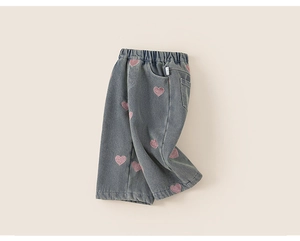 Detail view of light grey denim pants featuring pink heart embroidery and elastic waistband